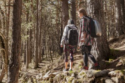 Dos jóvenes practican senderismo en un bosque